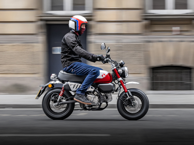 A rider on a Honda Monkey in an urban setting 