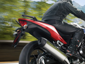 A rider on a Honda motorcycle with a blurred background of trees