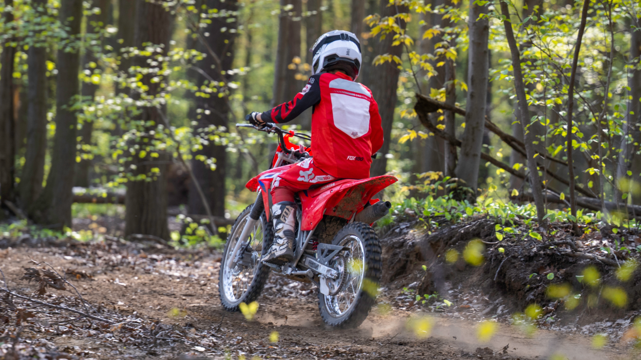 A young rider on a Honda CRF50F