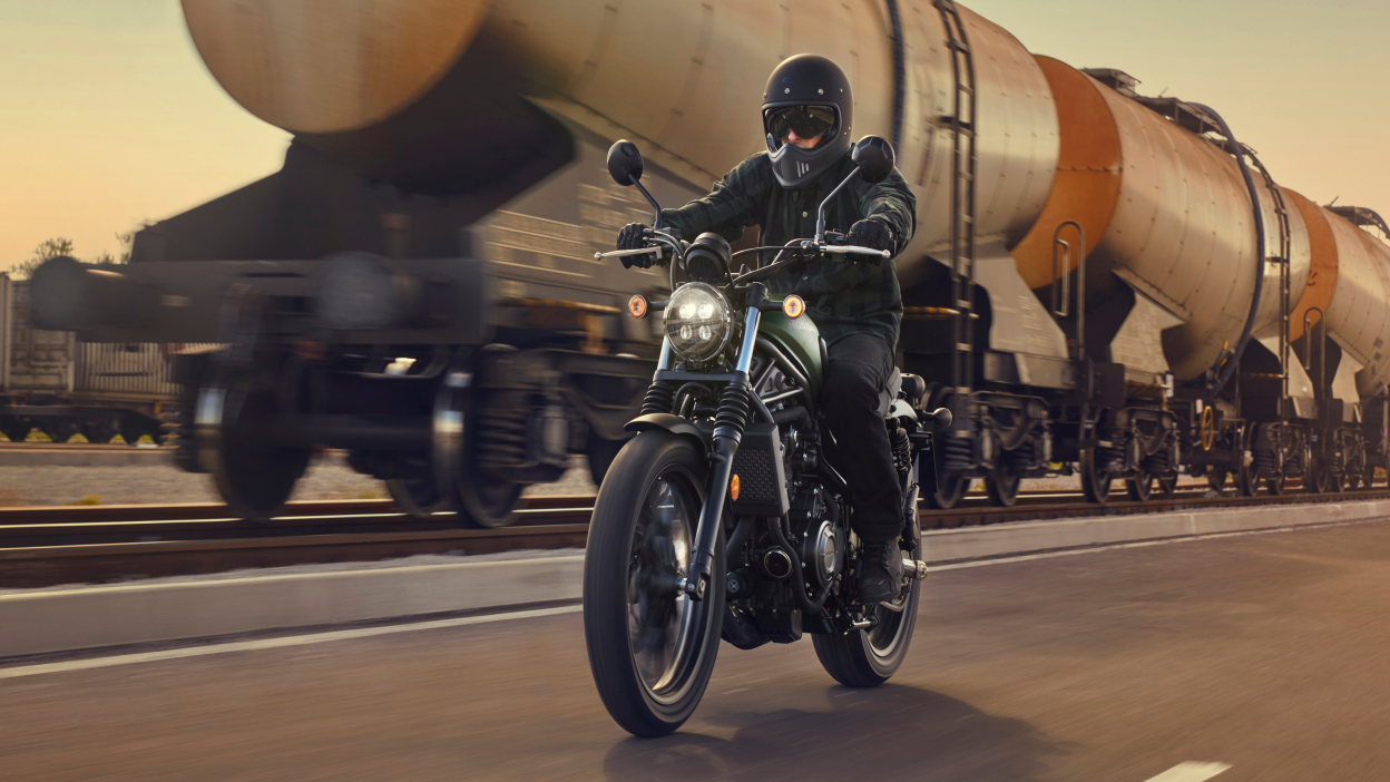 Une moto Honda Standard est montée à côté d'un train