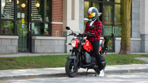 Un cavalier à cheval sur une Honda Navi près d'un espace vert