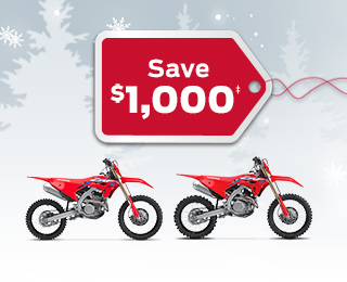 2 CRF Competition bikes on a winter background with snowflakes, with a red gift tag advertising a $1000 discount 